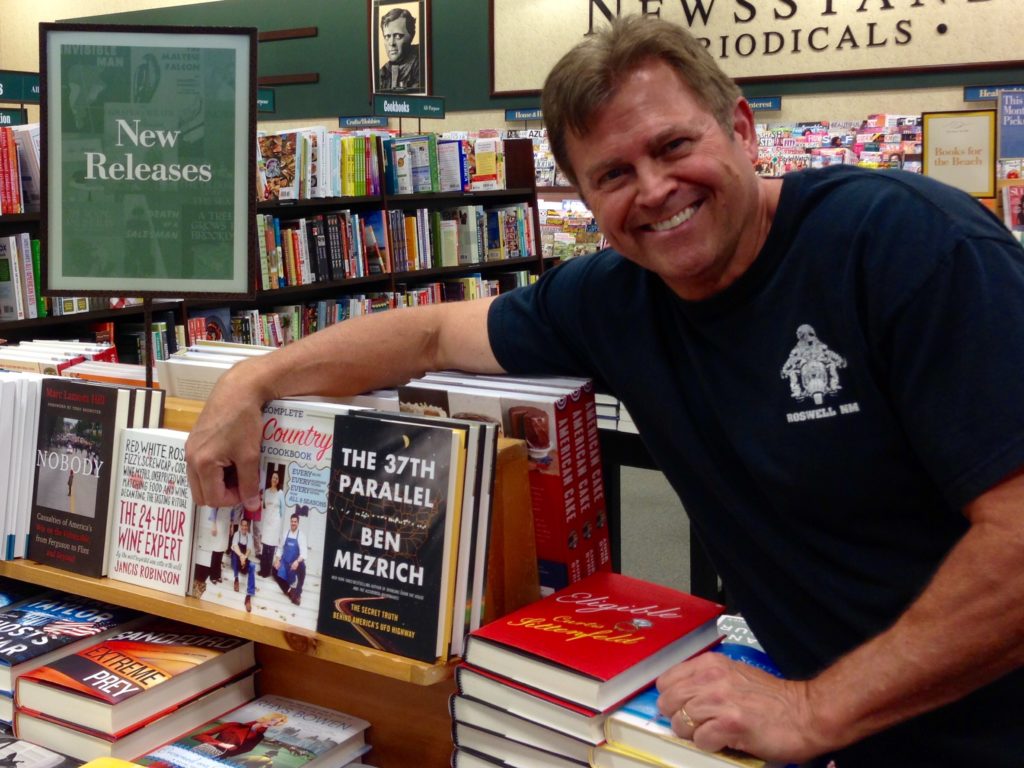 Standing next to The 37th Parallel book.